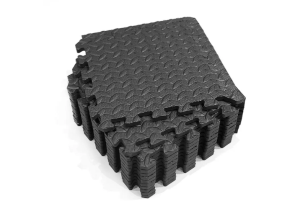 black interlocking gym mats stacked with white background