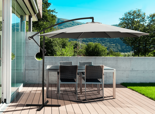 charcoal cantilever umbrella open on outdoor deck covering table and chairs