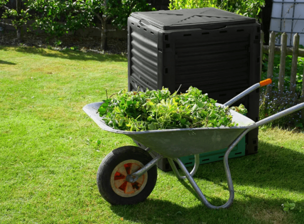 Compost Bin Waste Recycling 290L in backyard with wheelbarrow filled with grass